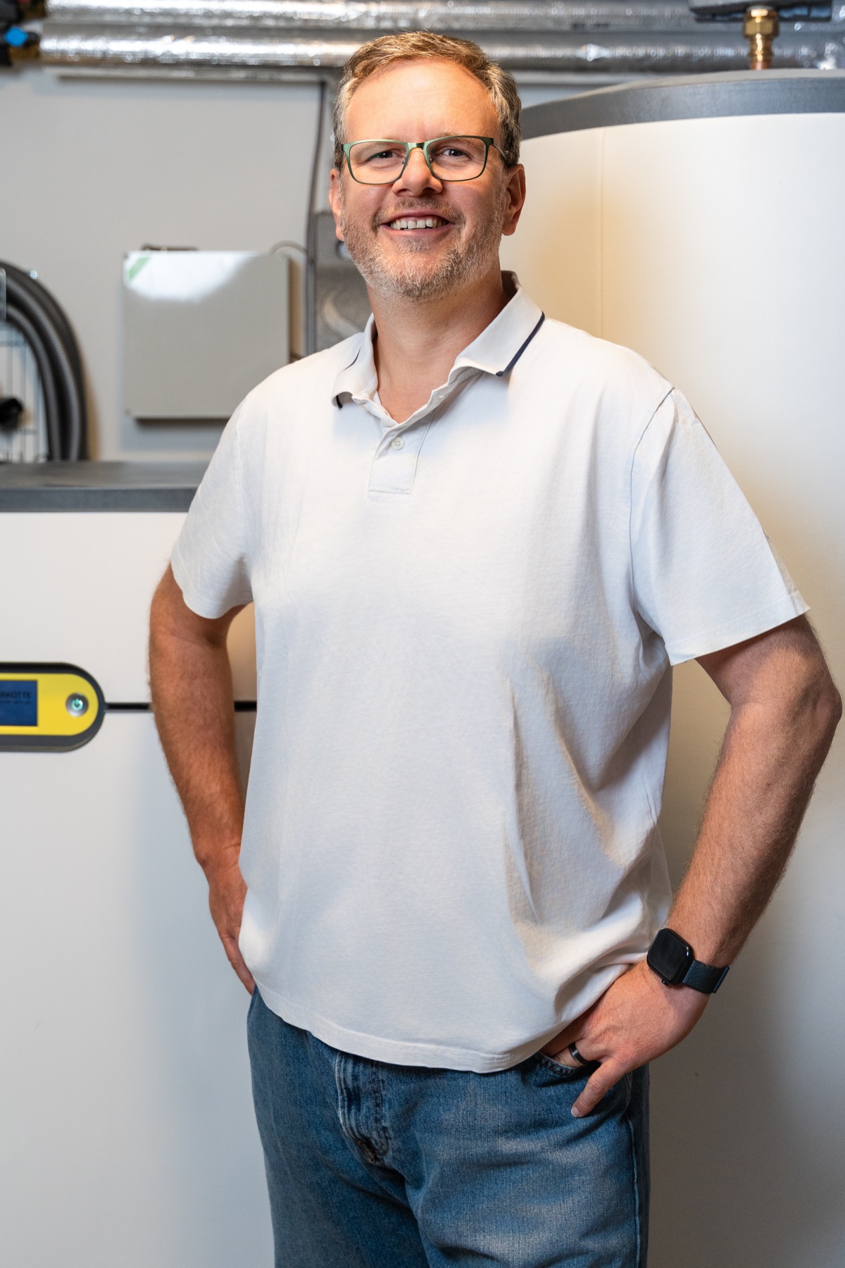 Christian Persch im Technikraum neben Pufferspeicher und Lüftungstechnik